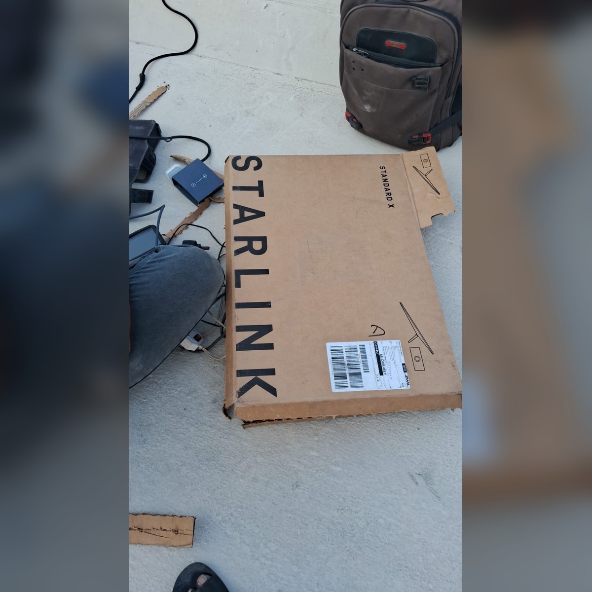 Starlink hardware box beside installation accessories